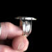 holding  side view, cushion black onyx gemstone bezel set bead wire and stamped cutout wire accent on tapered wide band